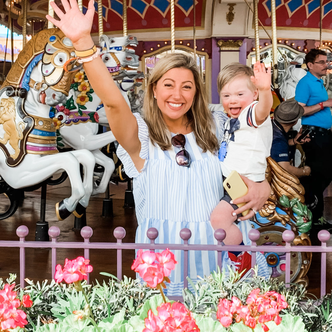 mom and toddler excited in front of the carousel at Disney World